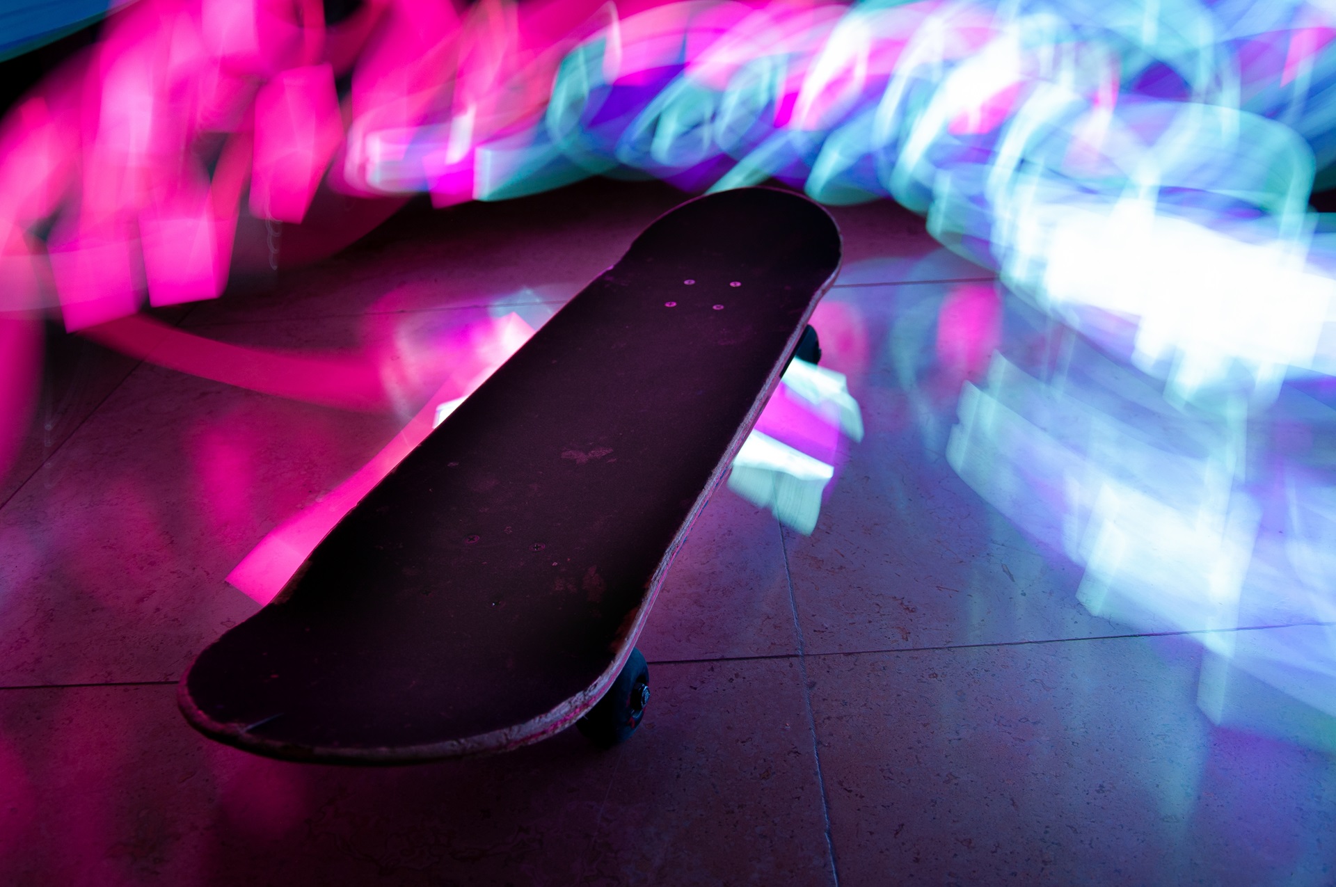 A timelapse shot of a skateboard with colorful light effects